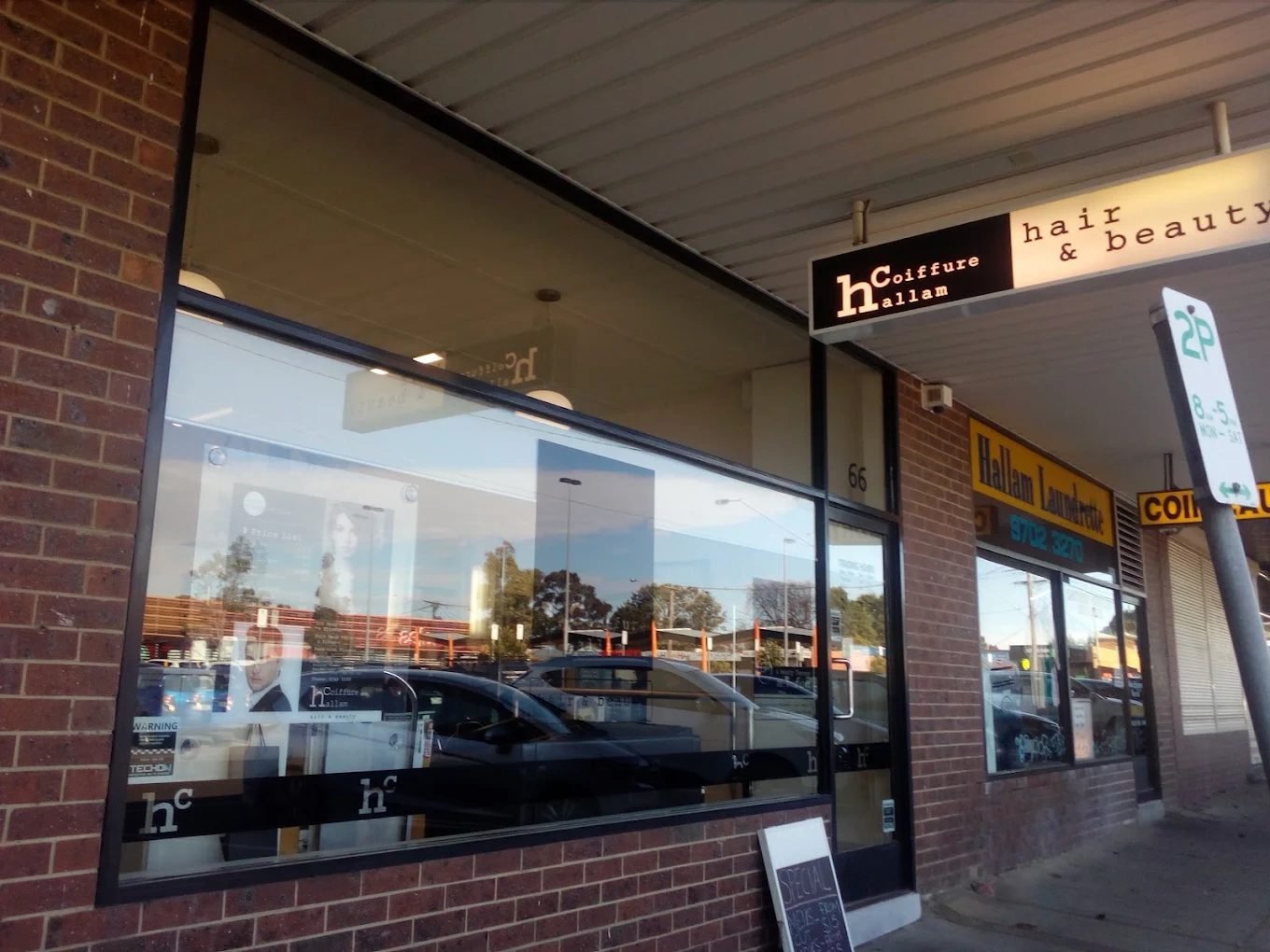 The Hallam Coiffure shopfront at 66 Spring Square: a brick shop with a large window and a black Coiffure Hallam sign under the verandah