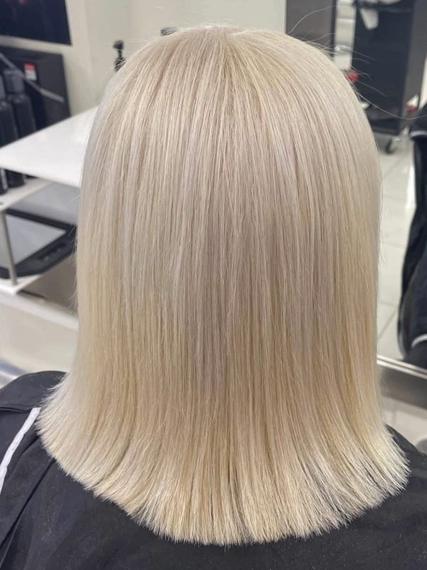 After: the same hair as an even, bright blonde blunt bob, seen from behind